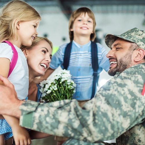 portrait of happy family and man in military uniform at airport